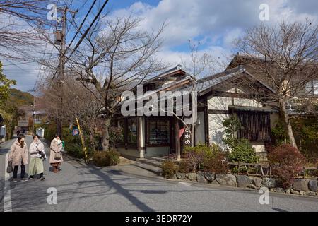Tre donne di mezza età che camminano insieme per strada in una brillante giornata invernale ad Arashiyama, Kyoto, Giappone. Foto Stock