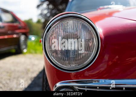 Zurigo, Svizzera, 19 aprile 2026. Un primo piano di un faro rotondo Bosch in vetro su un'auto rossa d'epoca presso Albisgüetli Classics. L'immagine mostra Foto Stock