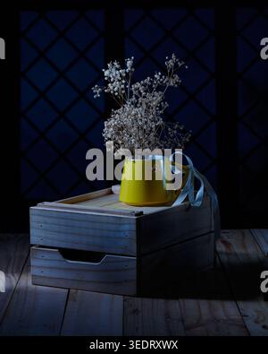 Alito del bambino essiccato in tazza gialla su cassa di legno sfondo scuro Foto Stock