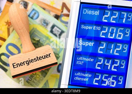 Timbro con l'iscrizione della tassa sull'energia sulle banconote in euro e sul listino prezzi presso una stazione di servizio, fotomontaggio Foto Stock