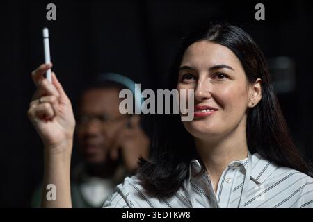 Ritratto della donna adulta che partecipa alla presentazione del team Foto Stock