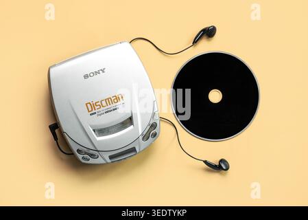 Vista dall'alto del lettore CD portatile Sony Discman con cuffie e CD musicali su sfondo giallo. Editoriale illustrativo Foto Stock