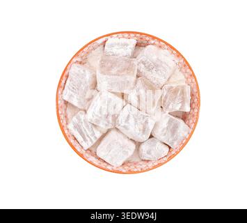 Lokum aromatizzato alla mandorla, o Turkish Delight, in una ciotola di ceramica arancione su sfondo bianco. Sono tradizionali cubetti di gelatina dolce. Vista dall'alto. Foto Stock