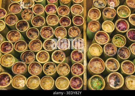 File di dolci dolci dolci arrostiti di riso al bambù. Immagine editoriale ad alto angolo che rappresenta la cultura gastronomica locale nella Thailandia centrale. Foto Stock