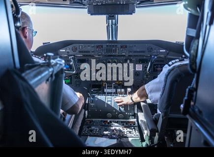 Ilulissat, Groenlandia - 17 luglio 2016: Aircraft Cockpit Interior with two Pilots Operating Flight Controls and Instrument Panel Foto Stock