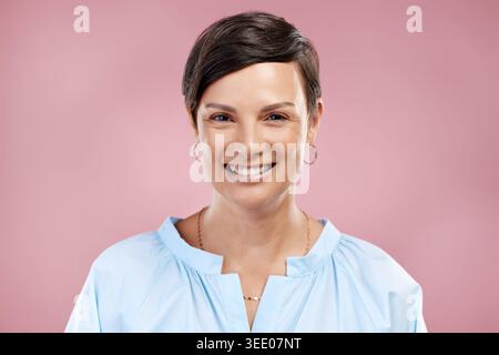 Felice, moda e ritratto della donna in studio con atteggiamento positivo, fiducia e abbigliamento. Sorridi, estetica e persona matura con abiti alla moda Foto Stock