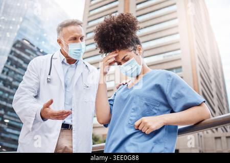 Medici, mal di testa e parlare con errore in ospedale con pressione, stress o maschera sul balcone. Persone, mentore e chirurgo con discussione Foto Stock
