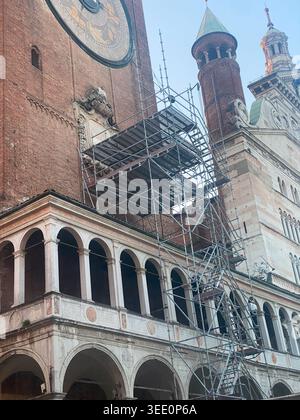 Cremona, Italia 9 aprile 2026 facciata storica a Cremona, Lombardia, Italia, caratterizzata da un grande orologio e archi con impalcature durante i restauri Foto Stock