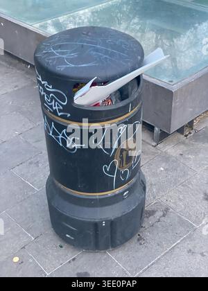 Cremona, Italia 9 aprile 2026 cestino nero traboccante di rifiuti e ricoperto di graffiti in Piazza Guglielmo Marconi, Cremona, Lombardia, Italia Foto Stock