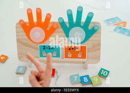 Primo piano di una tavola di conteggio in legno con elementi colorati. L'impostazione viene utilizzata per insegnare ai bambini la matematica di base e il riconoscimento dei numeri. Foto Stock