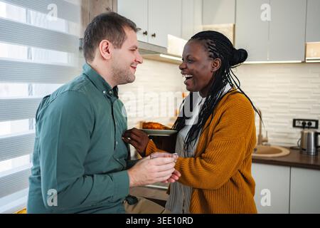Coppia interrazziale che ride e condivide un momento dolce Foto Stock