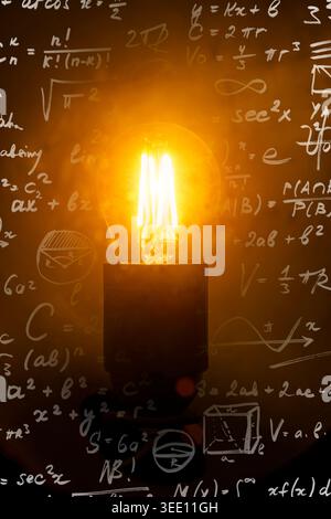 Lampadina a incandescenza con formule matematiche ed equazioni scientifiche. Foto di alta qualità Foto Stock