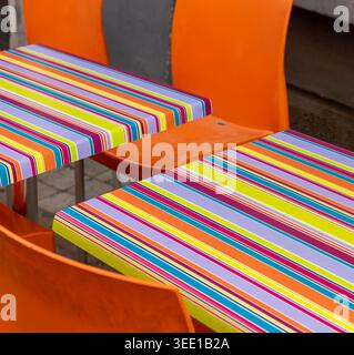 Sedie da caffè di colore arancione luminoso e tavoli a righe all'esterno di un ristorante chiamato le Renard Bleu, in Rue des Renards nella zona di Marolles a Bruxelles, Belgio. Foto Stock