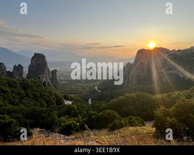 Tramonto mozzafiato sulle colonne rocciose e sugli antichi monasteri di Meteora, creando un paesaggio spettacolare nella Grecia centrale. Foto Stock