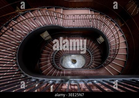 Vista dell'elegante scala a chiocciola all'interno dell'edificio principale TOKYO KAIKAN con i suoi intricati corrimano in legno e le balaustre in metallo scuro a Chiyoda C. Foto Stock