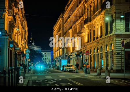 Lione, Francia - 19 marzo 2026: Vista notturna di una strada storica della città con edifici classici illuminati e calde luci dorate nel centro della città. Foto Stock