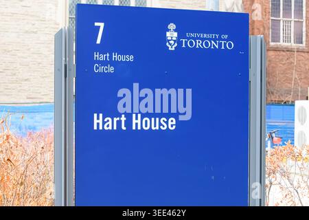 Insegna Blue Hart House su Hart House Circle con lo stemma dell'Università di Toronto e gli edifici del campus sullo sfondo. Foto Stock