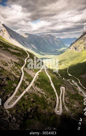 Vista aerea con droni dell'iconica strada di montagna Trollstigen Troll Path con leggendarie tornanti a serpentina che attraversano la profonda valle norvegese a Roms Foto Stock