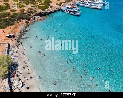 Vista ad alto angolo delle persone che nuotano in acque cristalline e turchesi in spiaggia Foto Stock