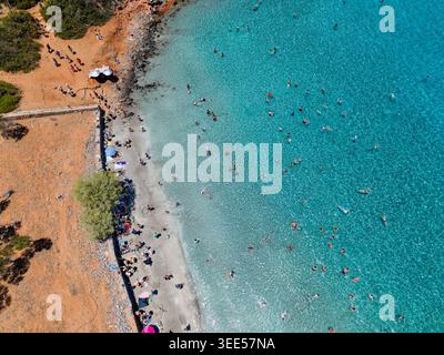 Vista aerea dei turisti che nuotano in acque turchesi cristalline in spiaggia Foto Stock