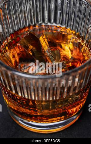 Cocktail di whisky con cubetti di ghiaccio in vetro di cristallo da vicino Foto Stock