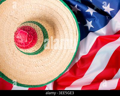 Cappello messicano sulla cima di una bandiera americana drappeggiata, simboleggia lo scambio culturale e la celebrazione. Foto Stock