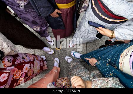Tokyo, Giappone. 15 aprile 2026. Le donne che indossano abiti tradizionali giapponesi sono fotografate vicino all'ingresso principale del tempio Sensō-ji nel quartiere Asakusa a Tokyo, in Giappone Foto Stock