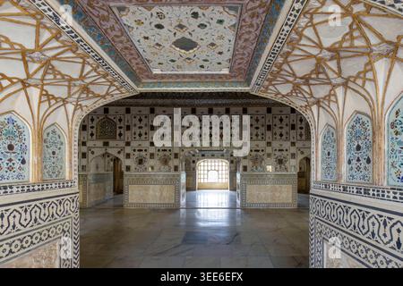 Interni ornati dello Sheesh Mahal o Mirror Palace presso il forte Amber di Jaipur, caratterizzati da intricata architettura moghul e motivi a mosaico di vetro Foto Stock