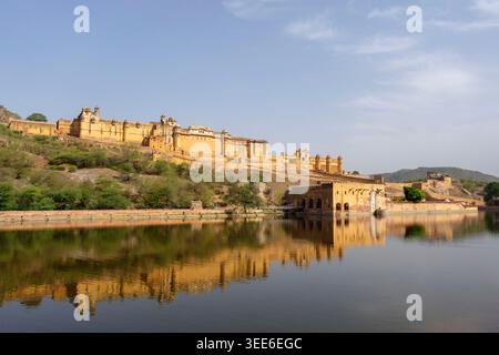 Vista panoramica del maestoso forte Amber che si riflette nel lago Maota sotto un cielo azzurro e limpido a Jaipur, Rajasthan, India Foto Stock