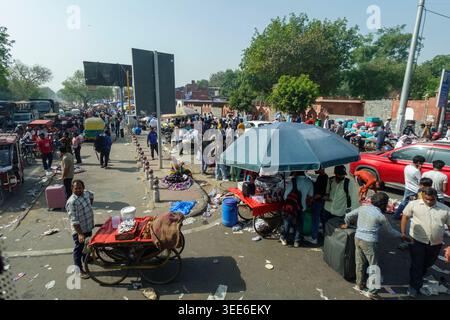 Vivace scena di strada a Delhi vicino al forte Rosso con folle di persone e venditori ambulanti che vendono merci su carrelli mobili sotto il sole Foto Stock