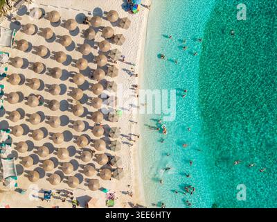 Vista aerea dall'alto verso il basso dell'affollata spiaggia di marmo il giorno della soleggiata, l'isola di Thassos in Grecia Foto Stock