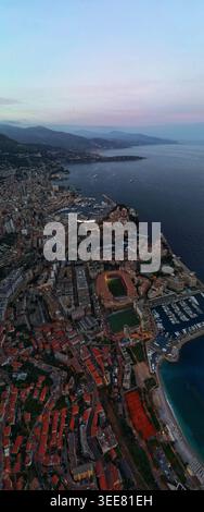 Vista aerea della città di Monaco con lo Stade Luigi II e il porto sotto un cielo crepuscolo Monaco, Monaco. Foto Stock