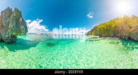 360 veduta della spiaggia di sabbia bianca di Entalula, El Nido, Palawan con palme ondeggianti, acqua turchese, tradizionali barche bangka e spettacolari formazioni carsiche di pietra calcarea Foto Stock