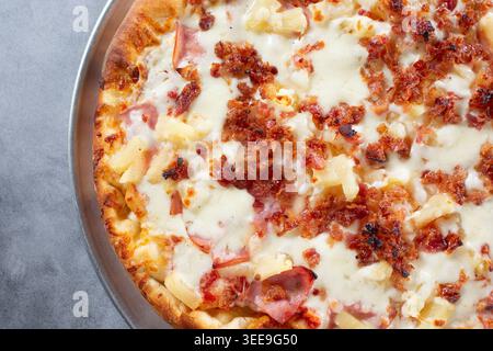 Una vista dall'alto verso il basso di una pizza hawaiana con pancetta. Foto Stock