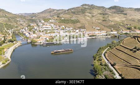 Vista aerea della città di Pinhao, annidata lungo il fiume Douro, con vigneti terrazzati e barche da crociera Pinhao, Vila Real, Portogallo. Foto Stock