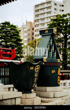 Tradizionale bruciatore di incenso e struttura ornamentale del santuario con moderni edifici cittadini sullo sfondo al tempio Sensō-ji, Asakusa, Tokyo, Jap Foto Stock