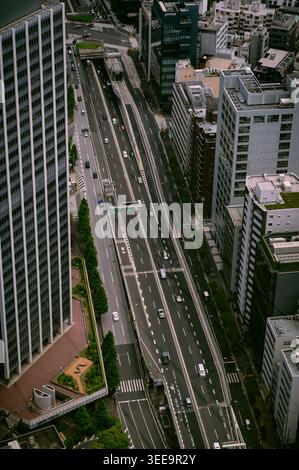 Vista sopraelevata della strada cittadina a più corsie con traffico tra grattacieli a Tokyo, Giappone Foto Stock