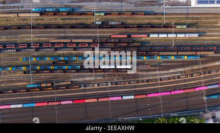 Praha, Cechia - 21 aprile 2026: Veduta aerea del cantiere di smistamento con treni merci colorati su più binari sotto la luce soffusa del giorno. Foto Stock