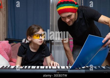 Padre che insegna musica a casa a figlia Foto Stock