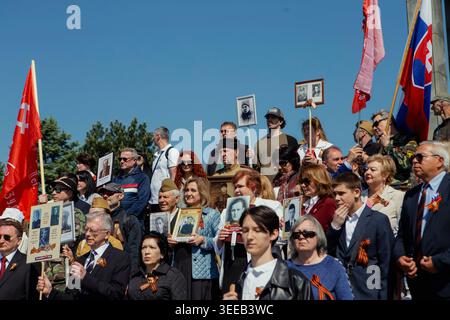 Bratislava, Slovacchia. 9 maggio 2026. I partecipanti tengono ritratti e bandiere legate al movimento del reggimento immortale al memoriale slavino di Bratislava, in Slovacchia, il 9 maggio 2026. La gente si riunisce al memoriale slavino per celebrare la giornata della Vittoria, un evento annuale che commemora la fine della seconda guerra mondiale. Il sito, un cimitero militare per soldati sovietici, attira partecipanti che espongono simboli russi e sovietici. (Foto di Elvis Takahashi mantello/Middle East Images/StringersHub/Sipa USA) credito: SIPA USA/Alamy Live News Foto Stock