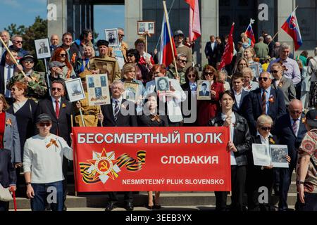 Bratislava, Slovacchia. 9 maggio 2026. I partecipanti tengono ritratti, bandiere e uno striscione rosso collegato al movimento del reggimento immortale al memoriale slavino di Bratislava, in Slovacchia, il 9 maggio 2026. La gente si riunisce al memoriale slavino per celebrare la giornata della Vittoria, un evento annuale che commemora la fine della seconda guerra mondiale. Il sito, un cimitero militare per soldati sovietici, attira partecipanti che espongono simboli russi e sovietici. (Foto di Elvis Takahashi mantello/Middle East Images/StringersHub/Sipa USA) credito: SIPA USA/Alamy Live News Foto Stock