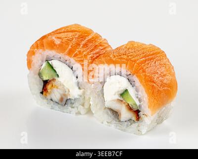 Primo piano di due freschi panini di sushi uramaki giapponesi. Una con salmone d'arancia, l'altra con l'anguilla. Ripieno di formaggio spalmabile e cetriolo. Cibo minimalista Foto Stock