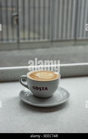 Latte mattutino in una tazza Costa appoggiata su una finestra. Londra, Regno Unito, 27 maggio 2024 Foto Stock