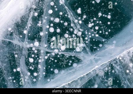 Sfondo naturale astratto di ghiaccio blu profondo con crepe e bolle d'aria ghiacciate sul lago Baikal in inverno, Siberia, Russia, vista dall'alto con spazio fotocopie Foto Stock