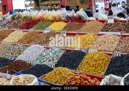 Assortimento di frutta secca, frutta secca, semi e caramelle in vassoi aperti presso l'Osh Bazaar di Bishkek, regione di Chuy, Kirghizistan, Asi centrale tradizionale Foto Stock