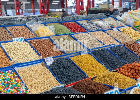 Assortimento di frutta secca, noci, semi e dolci esposti in contenitori aperti presso l'Osh Bazaar di Bishkek, regione di Chuy, Kirghizistan, mercato interno Foto Stock