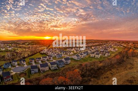 Una fotografia aerea con drone grandangolare di Clarksville, Howard County, Maryland, in autunno, fotografata al tramonto. Alberi decidui di colore autunnale incorniciano t Foto Stock
