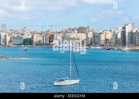 Sliema, Malta - 16 maggio 2025: Vista panoramica del lungomare di Sliema con yacht e skyline urbano attraverso il porto di Marsamxett in una tranquilla giornata di primavera a Malta. Foto Stock