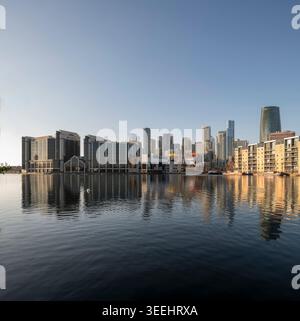 Lo skyline di Canary Wharf si riflette sul molo di Millwall a London Docklands, East London. Foto Stock