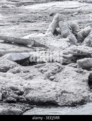 Vista ravvicinata del ghiaccio del fiume che si scioglie e di enormi blocchi di ghiaccio alla deriva durante la frantumazione primaverile su un fiume settentrionale. Suggestiva scena naturale con ghiaccio ruvido Foto Stock